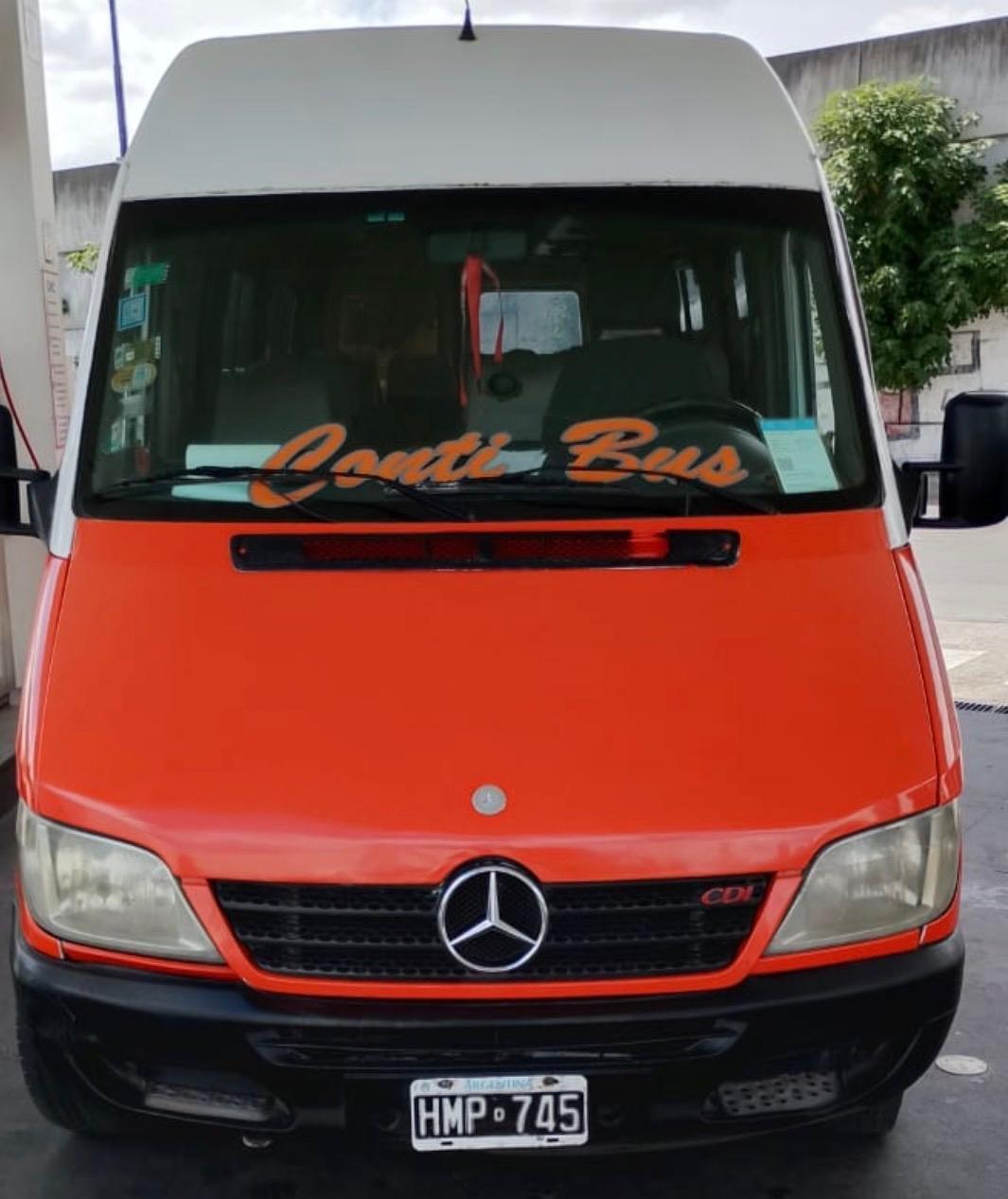 Frente de una camioneta roja de Conti Bus con el nombre de la empresa en el parabrisas